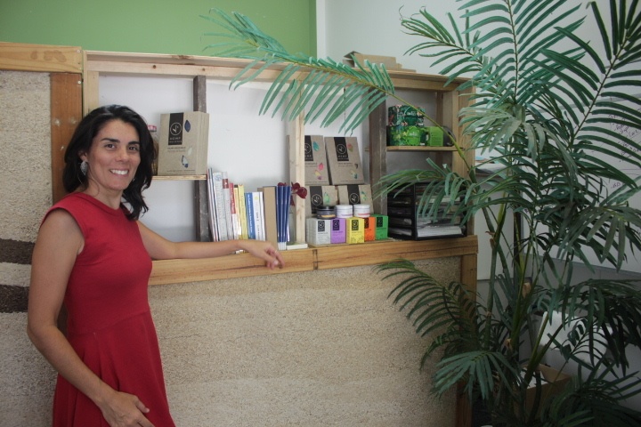 Maxine Shea poses with a collection of Hemp Collective products and a small hempcrete wall.
